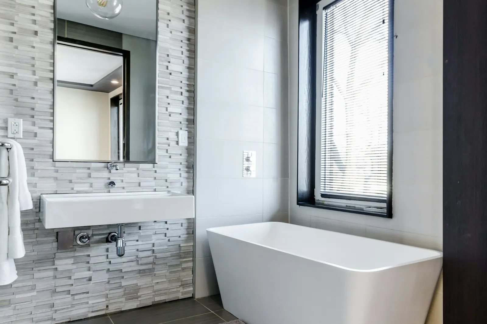 Salle de bains claire avec baignoire et fenêtre